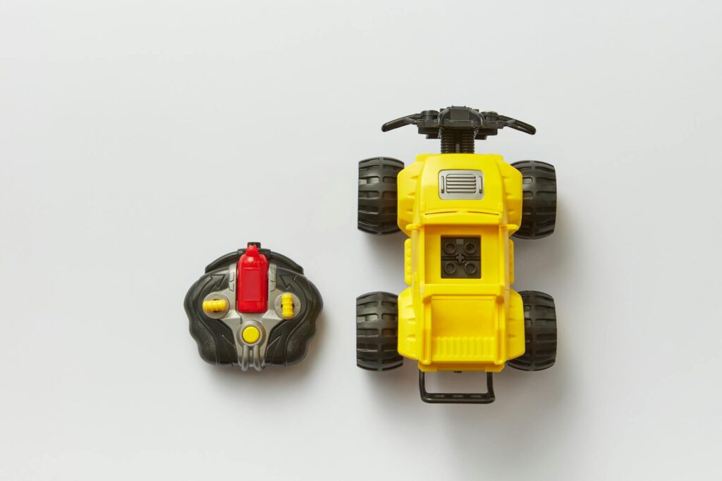 Top 5 Devices that Work Best with USB-C Rechargeable Batteries 3 Overhead view of a yellow remote-controlled toy car with its controller on a white background.